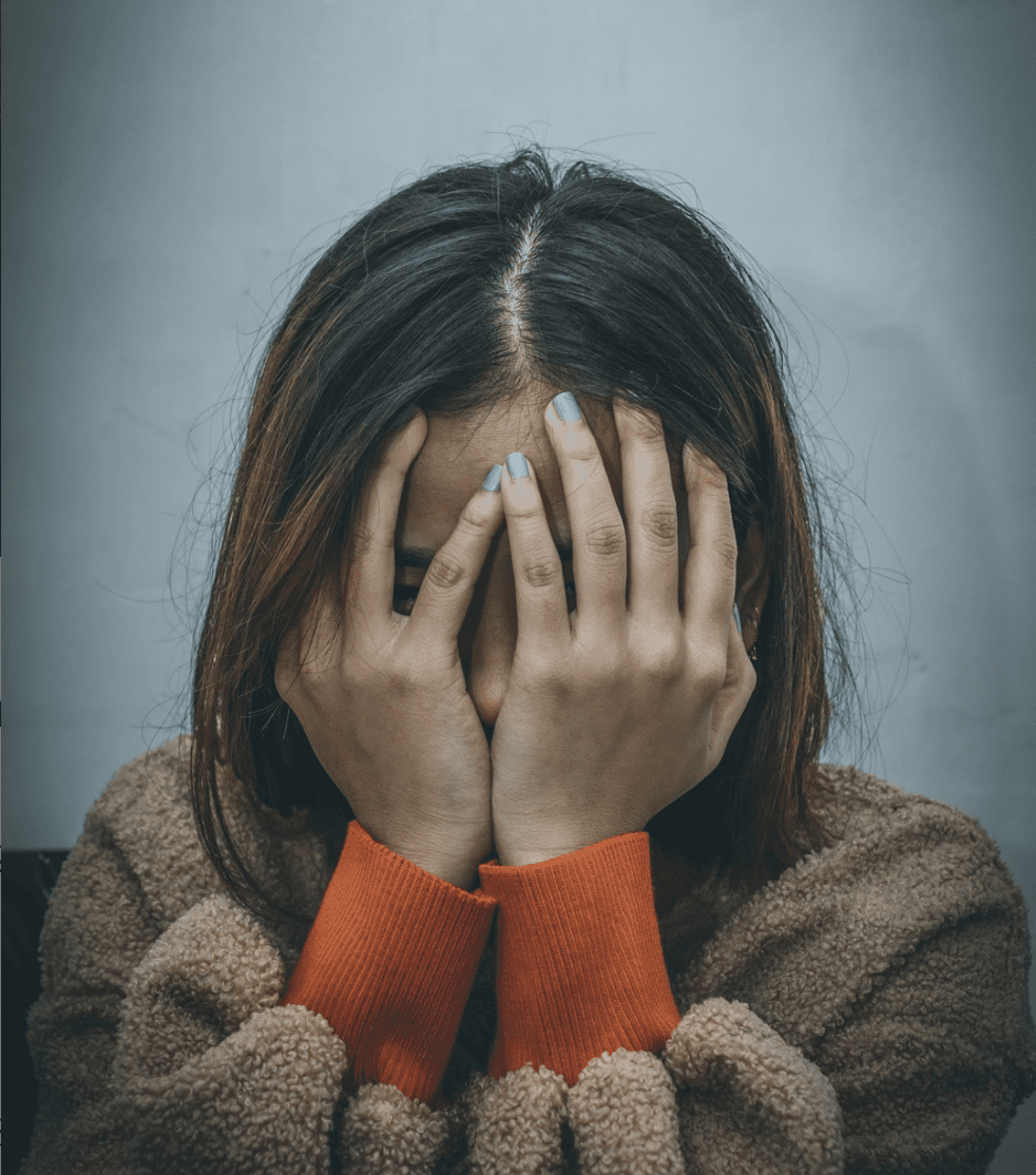 woman with her hands over her face in frustration